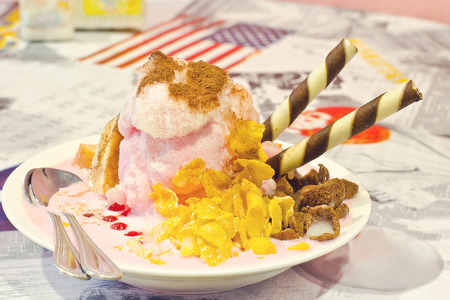 pink shaved ice desert on a plate with two spoons
