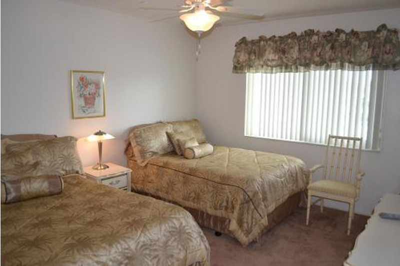 second room with two beds separated by a lamp gold colored