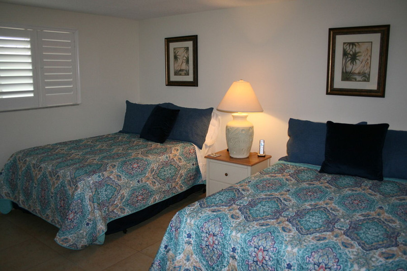 second bedroom with two full mattresses separated by a nightstand