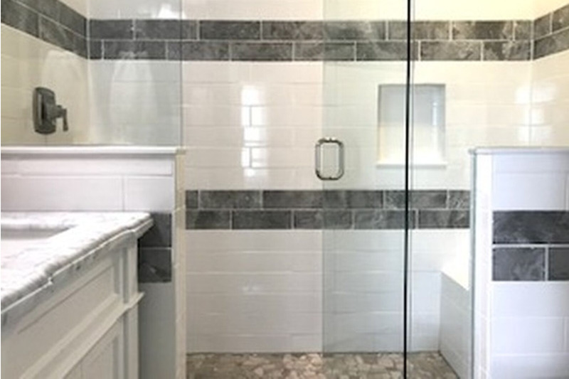 large walk in shower with bench seating and glass enclosure