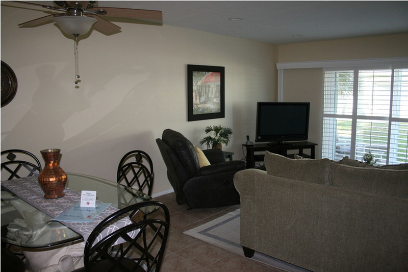 living room with dark lighting and chairs around a tv