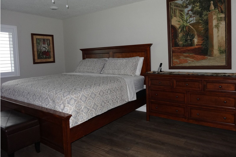 large bed in master bedroom with a dresser next to it