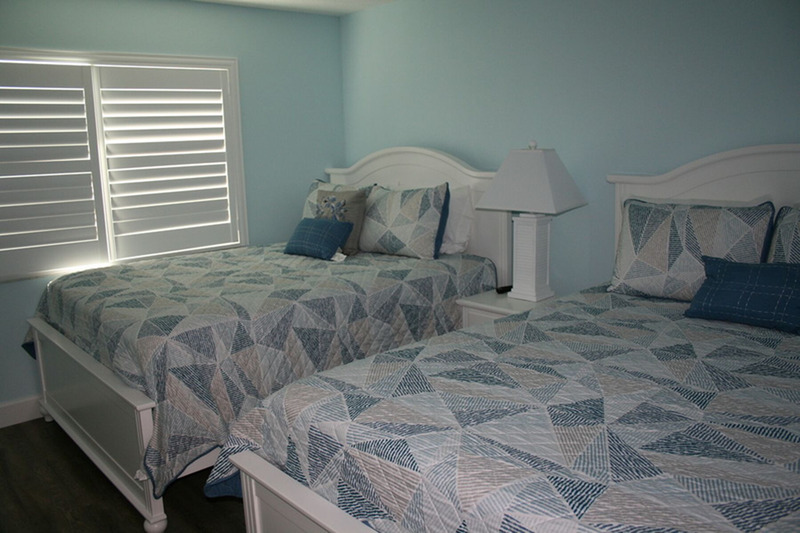 two blue beds in a spare bedroom
