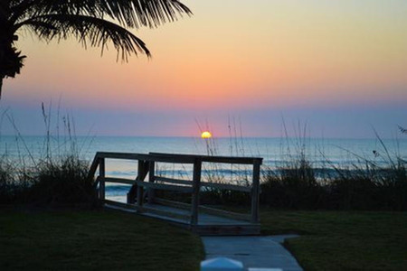 walkway to ocean at sunrise over the sand dunes 