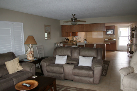 two brown couches and a kitchen