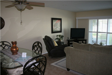 living room with dark lighting and chairs around a tv