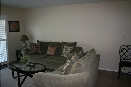 two couches in the form of an L facing a glass table 