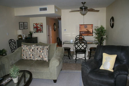 yellow walls surrounding a well furnished dining area and living room