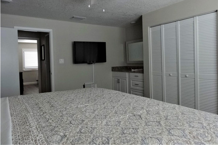 king bed with a large walk in closet in the master bedroom and a TV