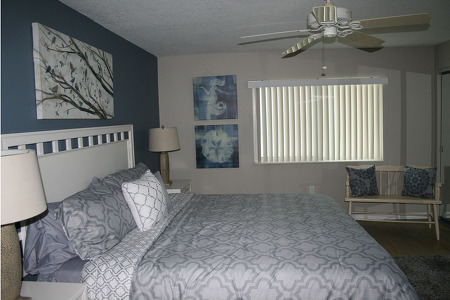 bedroom with a large bed in the middle and plenty of tree paintings