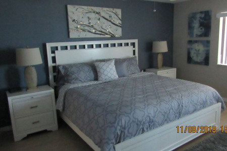 large blue sheeted bed with lamps on either side