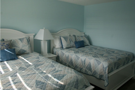 two blue beds in a spare bedroom