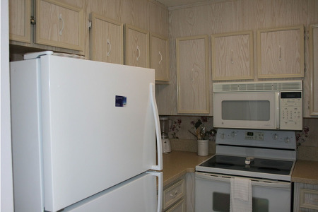 beige cabinets with a white fridge